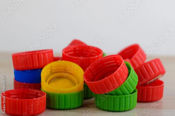 Fototapeta Multicolored plastic caps on wooden background