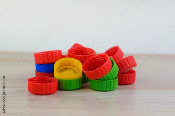 Fototapeta Multicolored plastic caps on wooden background