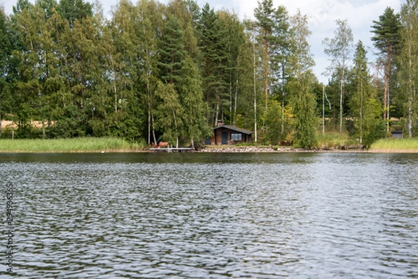Fototapeta Lake Hallanlahti summer view with reflection of clouds on water .