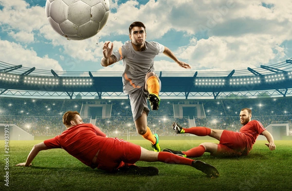 Obraz Three soccer players on a professional field fighting for the ball