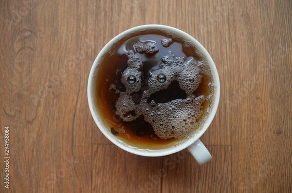 Fototapeta  Bubbles in cup of tea look like a face. Illustration of visual illusion - pareidolia.  Fantastic alien or goat with big eyes