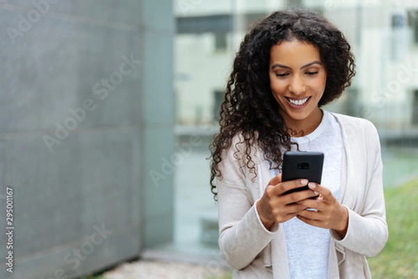 Obraz Młoda kobieta spacerując po mieście za pomocą telefonu komórkowego