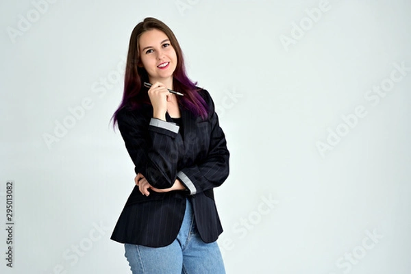 Fototapeta Studio portrait of a pretty brunette student girl with long hair in a jacket on a white background. Smiling at camera with emotions in various poses.
