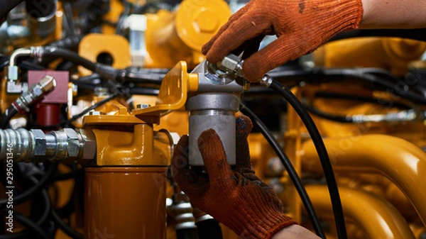 Obraz Low key photo of hydraulic pipes maintenance on heavy industry machine.