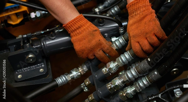 Obraz Niskie zdjęcie przedstawiające konserwację rur hydraulicznych na maszynie przemysłu ciężkiego.