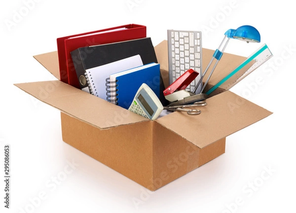 Fototapeta Cardboard moving box filled with office supplies, isolated on white background. Contains clipping path.