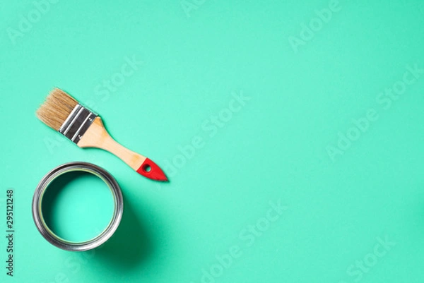 Fototapeta Paint brush and open paint can with on trendy green background. Top view, copy space. Appartment renovation, repair, building and home design concept.