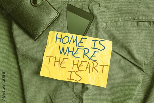 Fototapeta Writing note showing Home Is Where The Heart Is. Business concept for Your house is where you feel comfortable and happy Smartphone device inside trousers front pocket with wallet