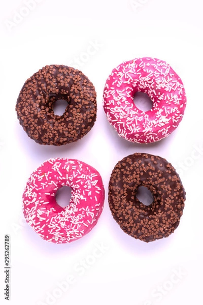 Fototapeta Two chocolate and two pink glazed tasty donuts laying isolated from each other