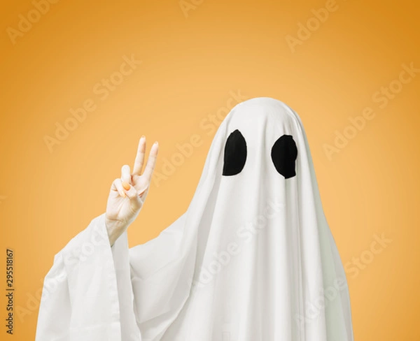 Obraz Halloweenowy biały duch pokazujący gest znaku pokoju na żółtym tle.