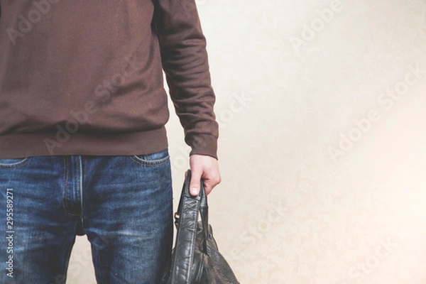 Fototapeta man in a casual style. a man in blue jeans with a bag in his hand