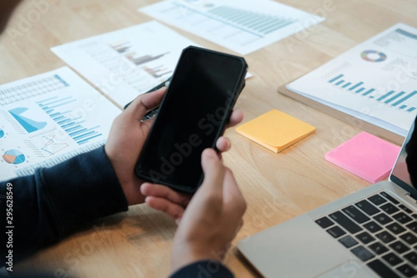 Fototapeta male freelancer using mobile smart phone. startup man working at workplace.