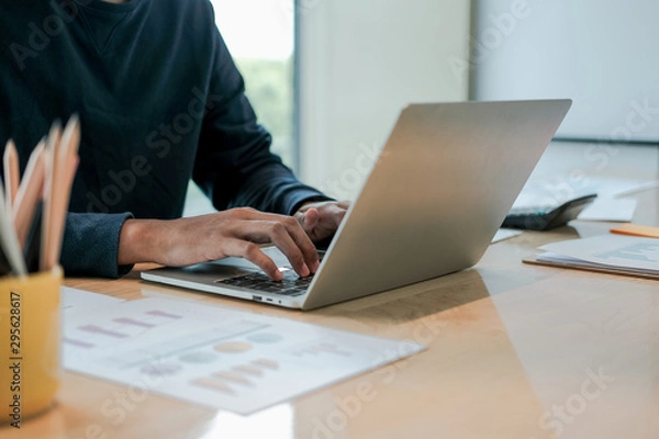 Fototapeta male freelancer working with computer document. startup man analyzing financial performance. student studying doing assignment