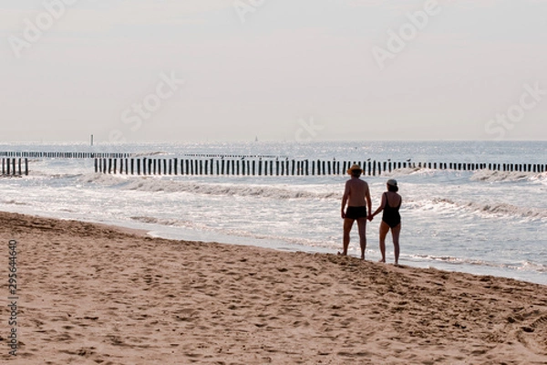 Obraz couple walking on the beach at sunset