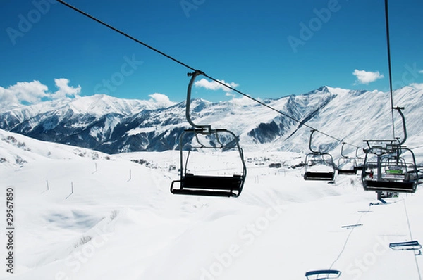Fototapeta Ski lift chairs on bright winter day