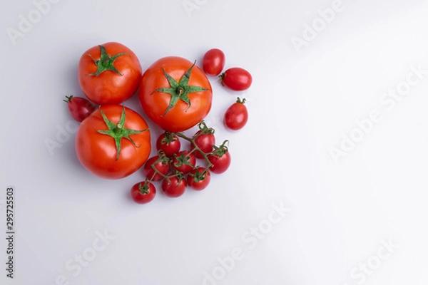 Fototapeta Grape or cherry tomato branch. Pile of red grape and normal tomatoes, isolated on white background, soft light