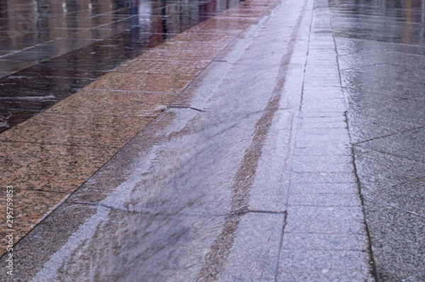 Obraz urban street gutter with water flow on tiled sidewalk at rainy day. background, weather.