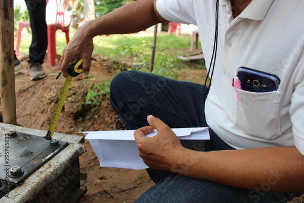 Fototapeta The technician is checking the size of the steel used in the construction of the base of the house. Take a blurred photo