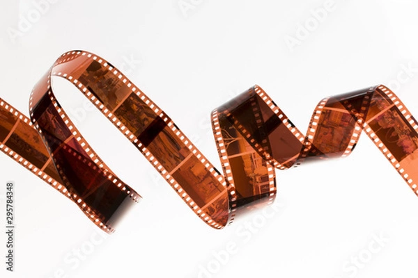 Fototapeta Slightly rolled undeveloped film strip isolated on white background