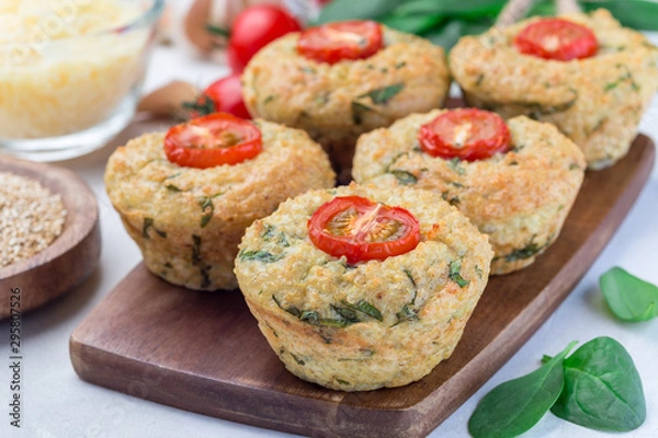 Fototapeta Savory muffins with quinoa, cheese and spinach topped with tomato, on  wooden board, horizontal