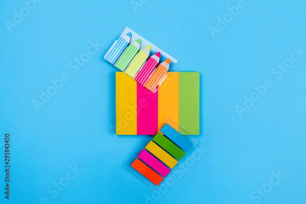 Obraz Sets of bright colored stickers in the form of stripes of yellow, pink, orange, green located on a blue background next to which are stickers in the form of stripes and pencils. Close-up.