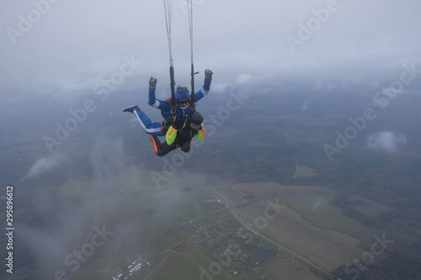 Fototapeta Skydiving. Tandem jump. An instructor and a passenger are flying  in the sky.