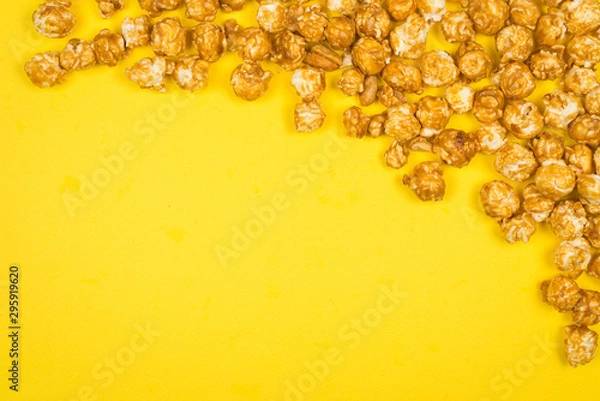 Fototapeta Caramel pop corn on yellow background. Copy space.