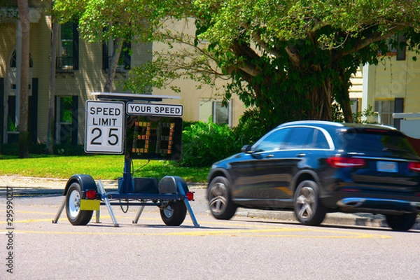 Fototapeta Radar speed limit indicator sign monitored by the police showing 31 miles per hour on the screen proving a passing car is speeding as it drives down the road.