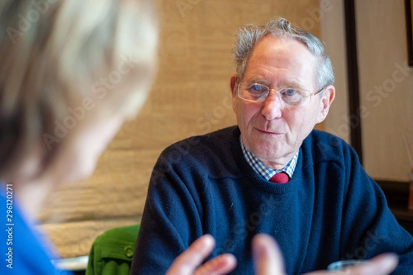 Obraz Happy elderly man listens intently while maintaining eye contact