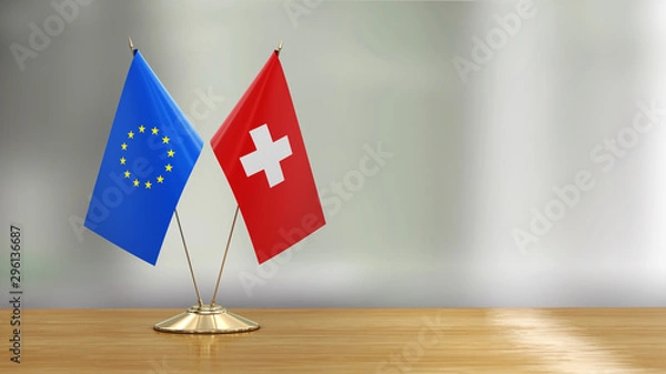 Obraz European Union and Swiss flag pair on a desk over defocused background 