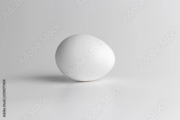 Obraz one chicken raw egg on grey neutral background. Close-up and side view