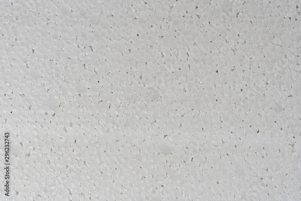 Fototapeta White abstract polystyrene foam background texture close-up detail view. Polystyrene, styrofoam, plastic sheet abstract synthetic packaging material.