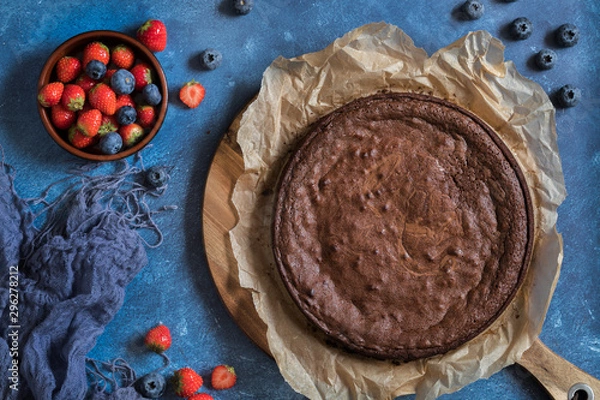Obraz Chocolate cake seen from above, with a bowl of berries - strawberries and blueberries
