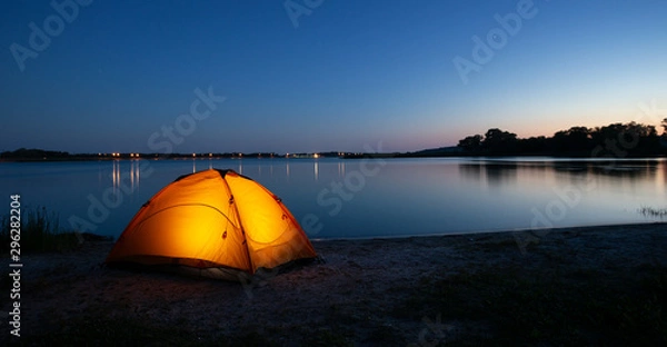 Obraz Orange interior lit tent on a lake at dusk