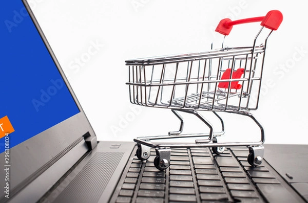 Fototapeta Many boxes in a trolley on a laptop keyboard,on brick background. Ideas online shopping is a form of electronic commerce that allows consumers to directly buy goods from a seller over the internet.