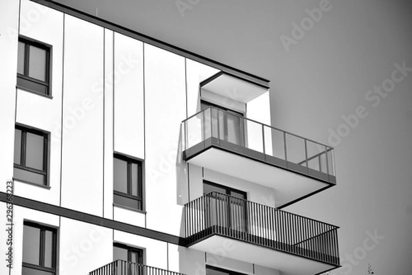 Fototapeta  Fragment of a facade of a building with windows and balconies. Modern home with many flats. Black and white.