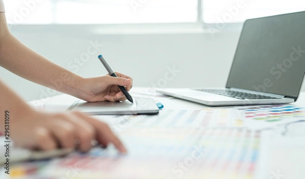 Fototapeta Graphic designer at work. Color swatch samples. Artist drawing something on graphic tablet at the office. Graphic designer creativity editor ideas designer concept