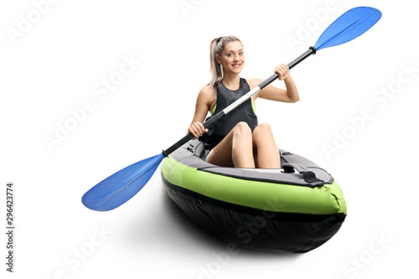 Fototapeta Young female in a canoe with paddles smiling