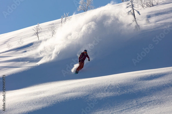 Obraz Extreme snowboarder has fun riding fresh powder snow off piste in white mountains. Pro rider snowboarding and carving freshly fallen snow in mountain wilderness. winter extreme sports background