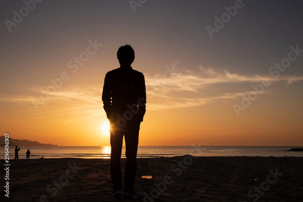 Obraz サンセットビーチに立つ男性の後ろ姿