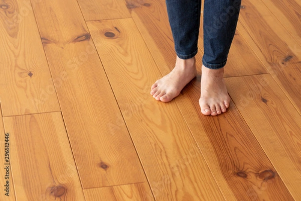 Fototapeta 木目の床と若い女性の足元のアップ