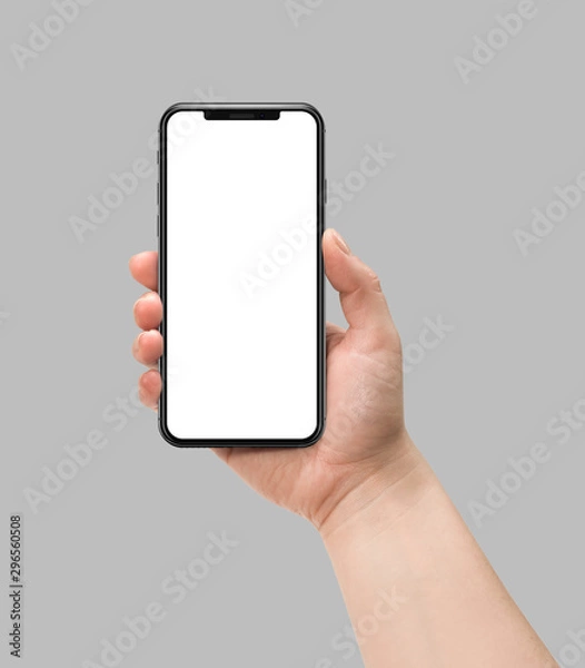 Obraz Woman hand holding smart phone with blank screen isolated on gray. Template, mockup, model, modern, design.	