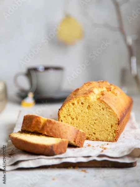 Fototapeta Pumpkin cake on beige dish cloth with cup of tea, glass of milk and tree branch on background. Autumn dessert.