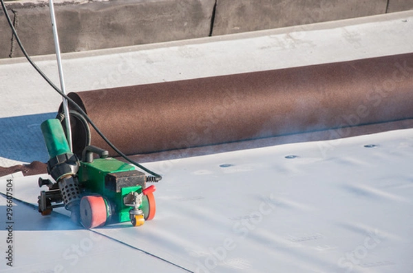 Fototapeta Construction device for installing waterproofing materials on the roof