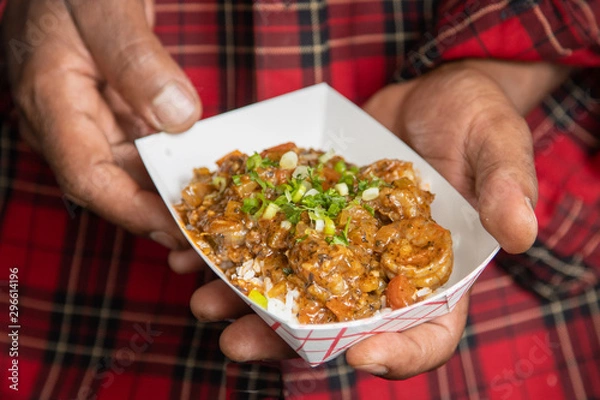 Fototapeta Closeup shrimp creole horizontal holding with two hands