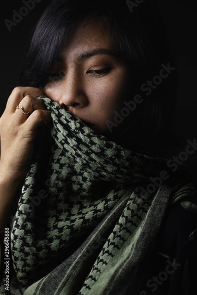 Fototapeta woman with freckles on the face Wearing a headdress and scarf with ornaments made of leather and rings On a black background and shadows