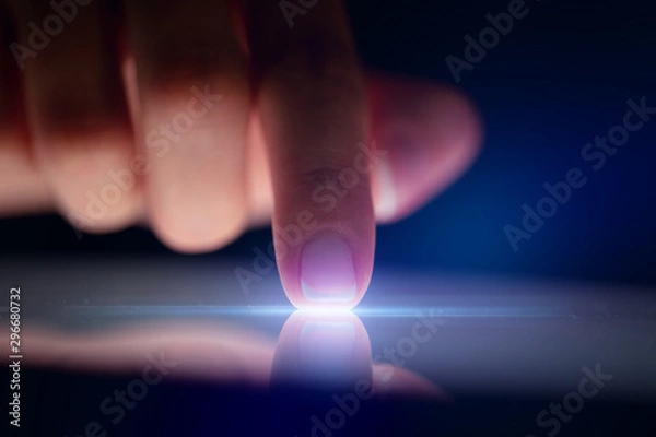 Obraz Finger touching tablet with dark background with copyspace
