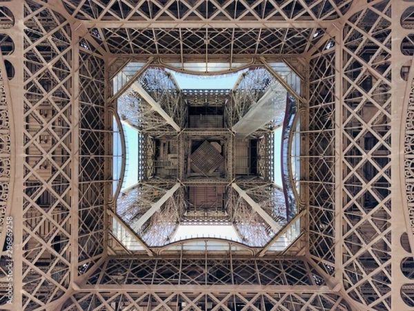Fototapeta View looking straight up from underneath the Eiffel Tower in Paris, France