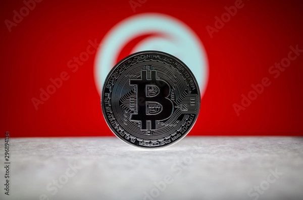Fototapeta Physical silver version of Bitcoin (BTC) and Tunisia Flag on the background. Conceptual image for investors in cryptocurrency and Blockchain Technology.