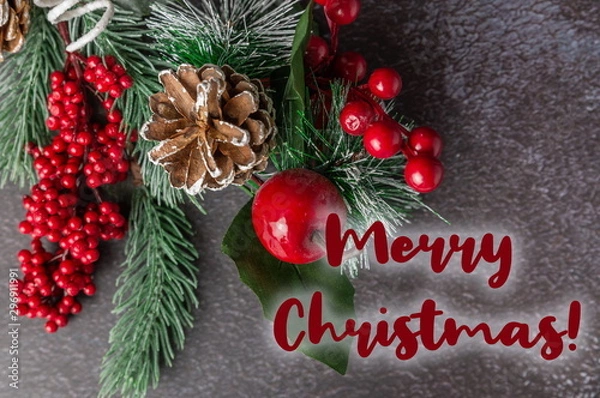 Fototapeta Christmas fir twig with berries on dark background with the insc